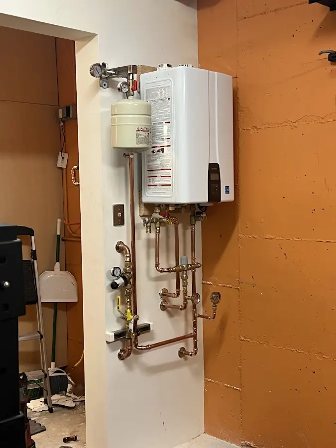 Plumbing technician inspecting water heater connections in Boonsboro